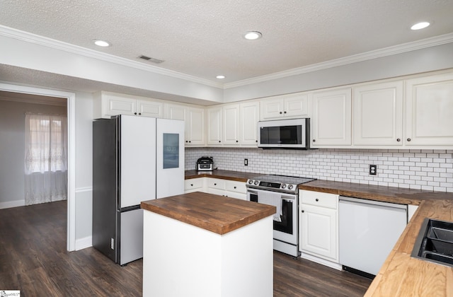 kitchen with a kitchen island, butcher block counters, white cabinets, dark hardwood / wood-style flooring, and white appliances