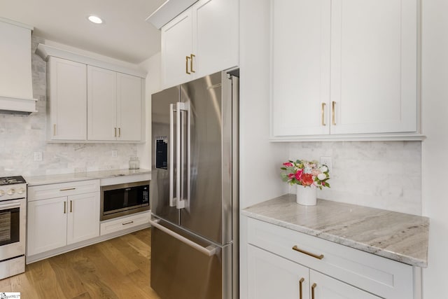 kitchen with built in microwave, white cabinets, high end fridge, white gas stove, and light hardwood / wood-style flooring