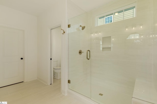 bathroom featuring an enclosed shower and toilet