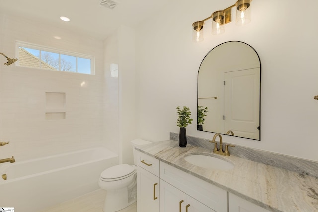 full bathroom with vanity, tiled shower / bath, and toilet