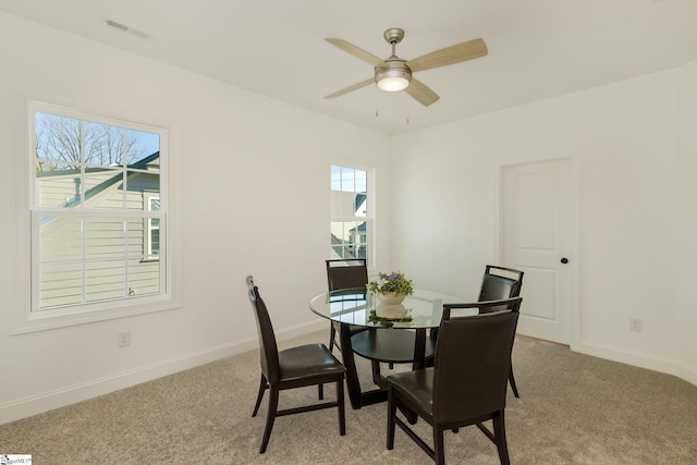 dining area featuring light carpet and ceiling fan