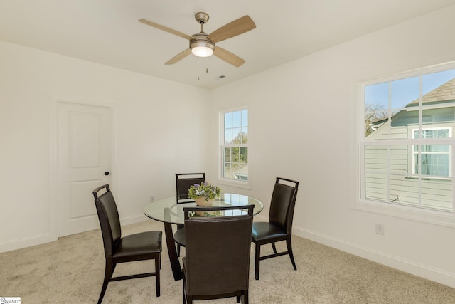 carpeted dining space with ceiling fan