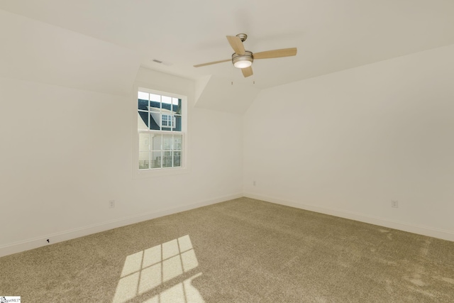 empty room with ceiling fan, vaulted ceiling, and carpet