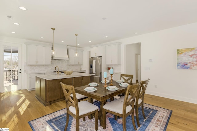 dining area with sink and light hardwood / wood-style floors