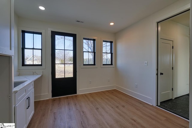 doorway to outside with light hardwood / wood-style floors and a wealth of natural light