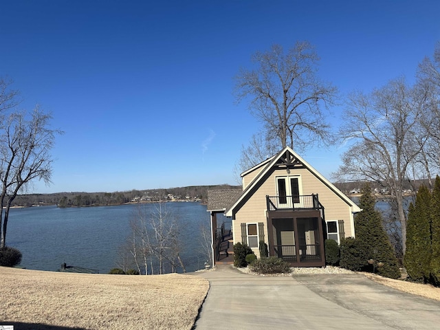 view of front of house featuring a water view and a balcony