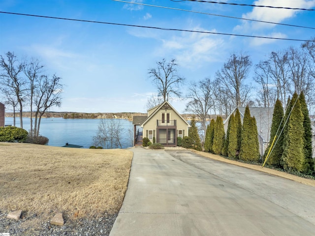 view of front of house featuring a water view, a porch, and a front lawn