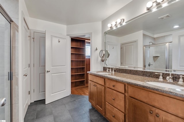 bathroom featuring tile patterned floors, vanity, and a shower with shower door