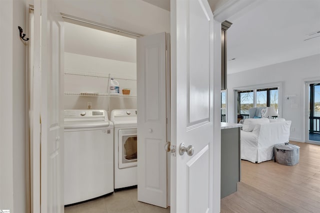 laundry room with independent washer and dryer and light wood-type flooring