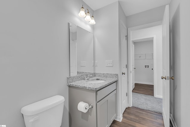 bathroom featuring vanity, wood-type flooring, and toilet