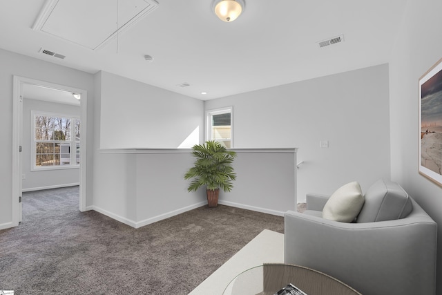 sitting room featuring a wealth of natural light and dark colored carpet