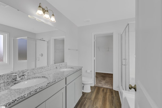 bathroom featuring vanity, toilet, hardwood / wood-style floors, and walk in shower