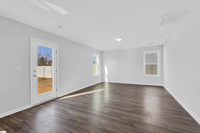 unfurnished room with dark wood-type flooring and plenty of natural light