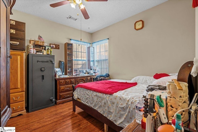 bedroom featuring hardwood / wood-style flooring, ceiling fan, and a textured ceiling