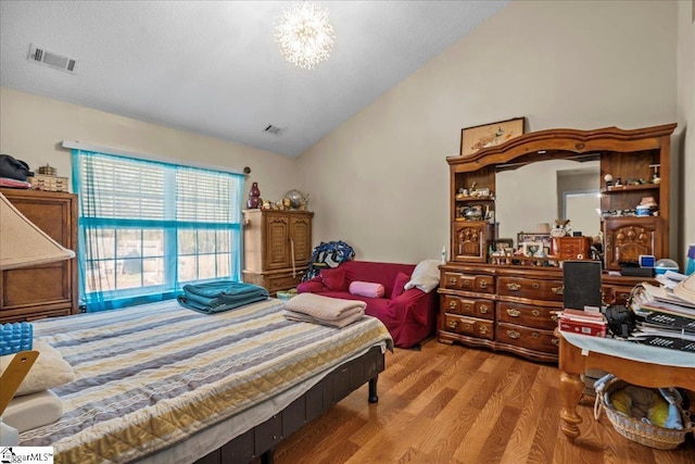 bedroom with lofted ceiling and light hardwood / wood-style floors