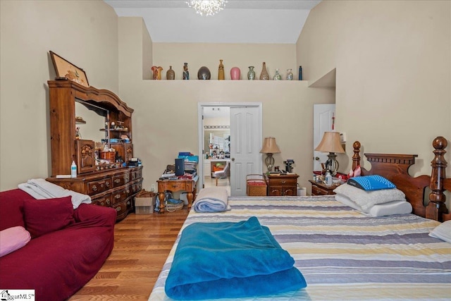 bedroom with hardwood / wood-style flooring and a towering ceiling