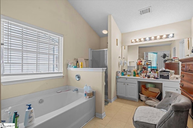 bathroom featuring vaulted ceiling, independent shower and bath, vanity, tile patterned floors, and a textured ceiling