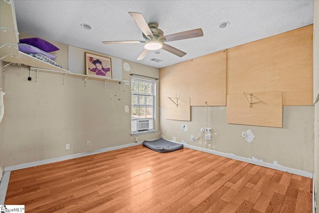 spare room featuring ceiling fan, hardwood / wood-style floors, a textured ceiling, and cooling unit