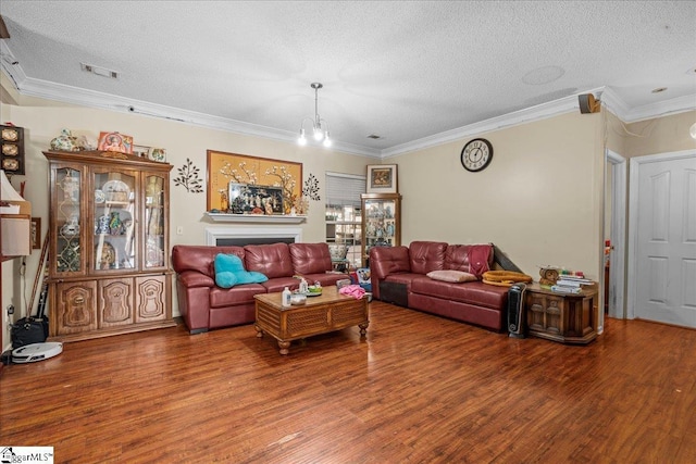 living room featuring ornamental molding, a chandelier, hardwood / wood-style floors, and a textured ceiling