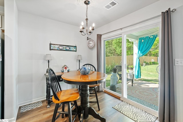 dining area featuring an inviting chandelier and light hardwood / wood-style flooring