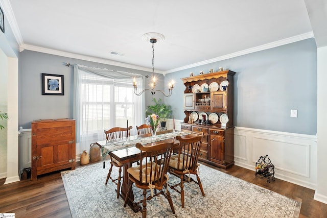 dining room featuring ornamental molding, dark wood-type flooring, and an inviting chandelier