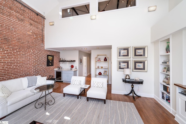 living room with hardwood / wood-style flooring, a high ceiling, and built in features