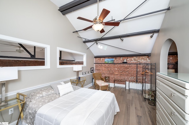 bedroom featuring dark wood-type flooring, brick wall, beam ceiling, and high vaulted ceiling