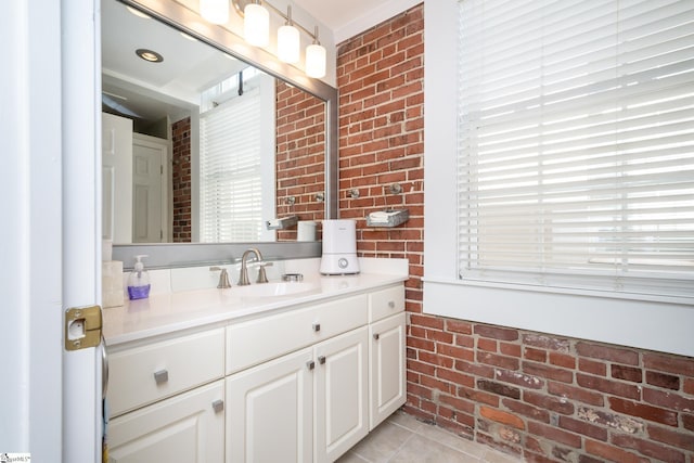 bathroom with vanity, tile patterned floors, and brick wall