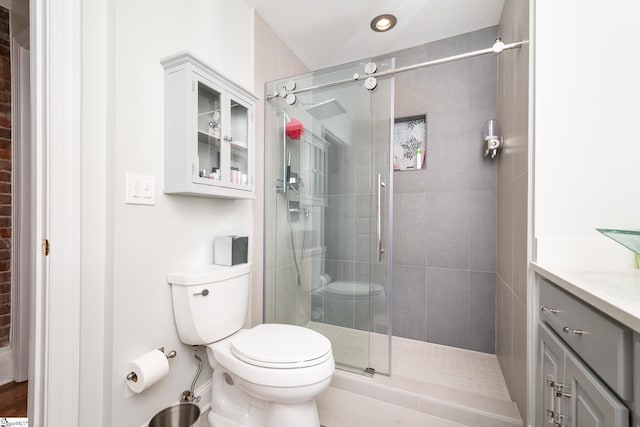 bathroom with an enclosed shower, vanity, and toilet