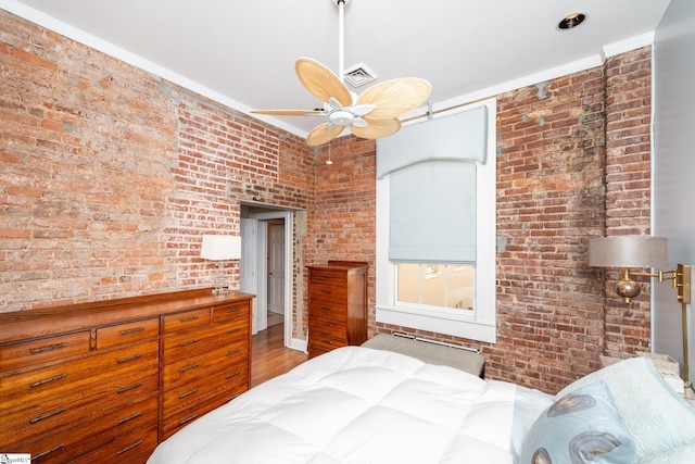 unfurnished bedroom featuring crown molding, brick wall, and wood-type flooring