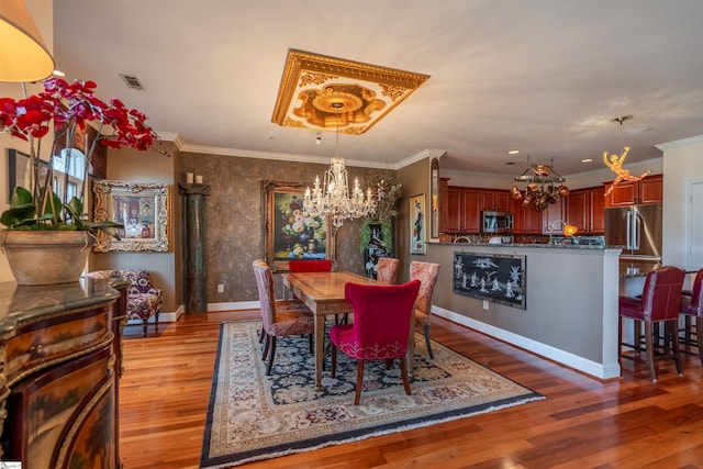 dining room with a notable chandelier, hardwood / wood-style flooring, and ornamental molding