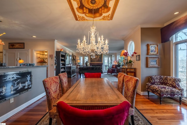 dining space featuring hardwood / wood-style flooring, crown molding, and a chandelier