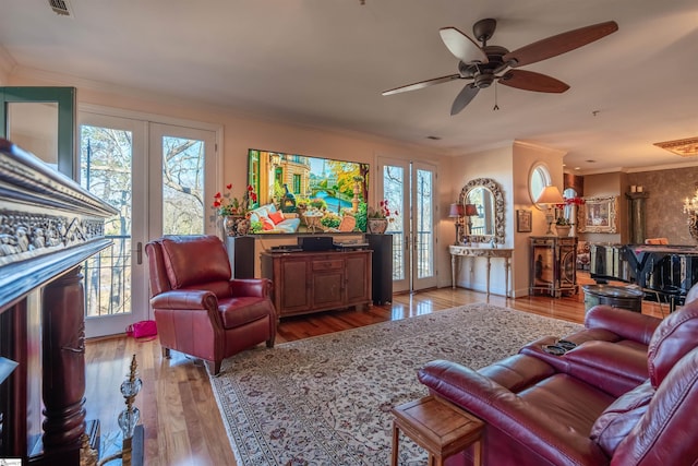 living room with ornamental molding, light hardwood / wood-style floors, ceiling fan, and plenty of natural light