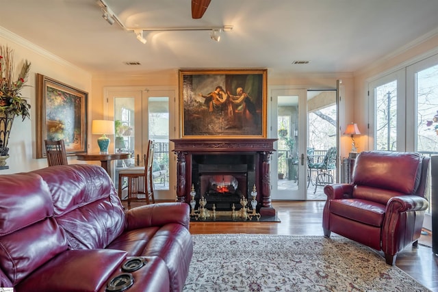 living room with crown molding, wood-type flooring, and french doors