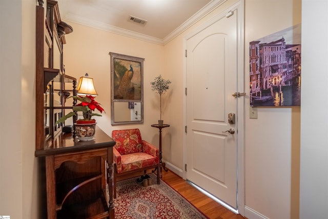 entryway with ornamental molding and wood-type flooring