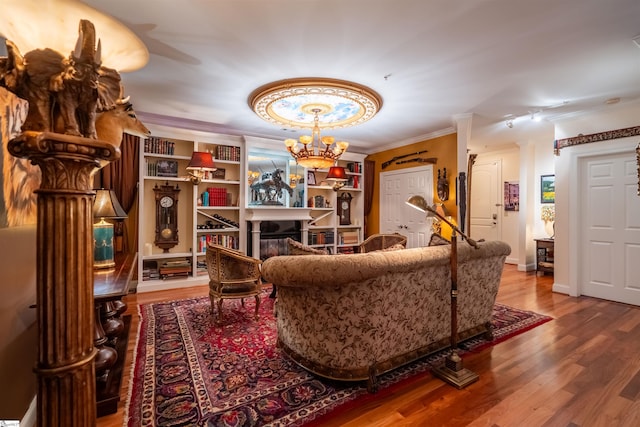 living room featuring hardwood / wood-style floors, ornamental molding, and a chandelier