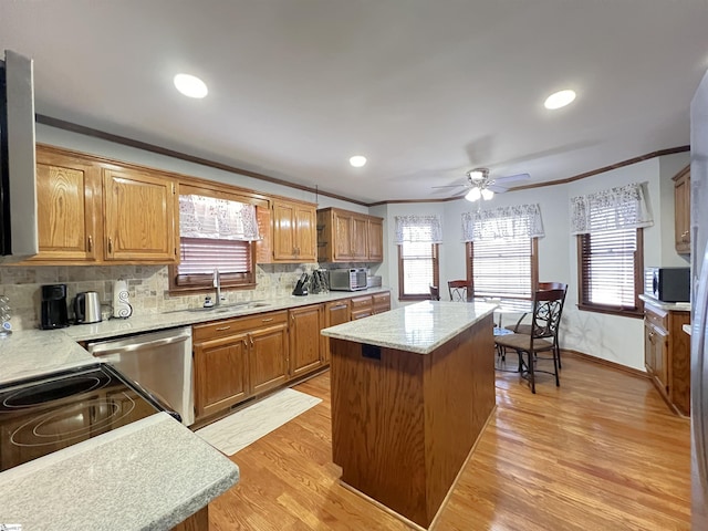 kitchen featuring crown molding, a center island, dishwasher, and light wood-type flooring