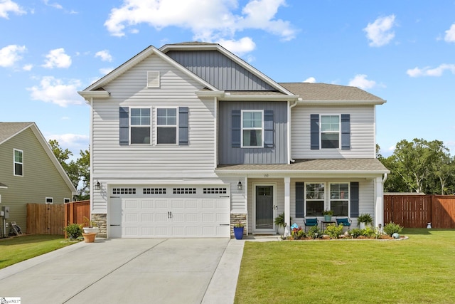 view of front of property featuring a garage, a front yard, and covered porch