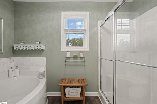 bathroom with independent shower and bath and hardwood / wood-style floors