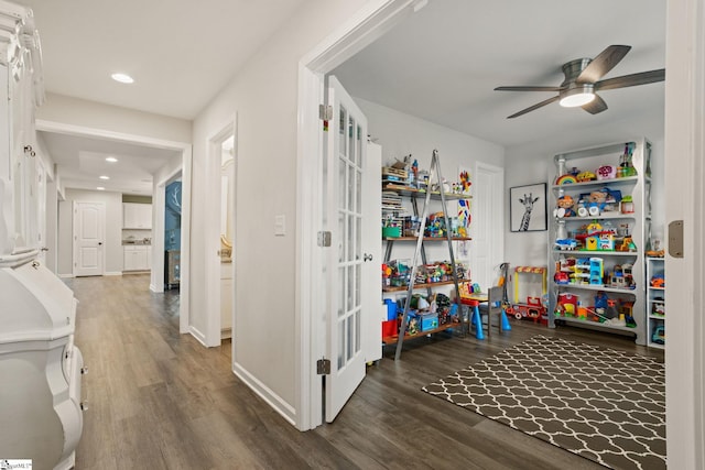 playroom with dark wood-type flooring and ceiling fan