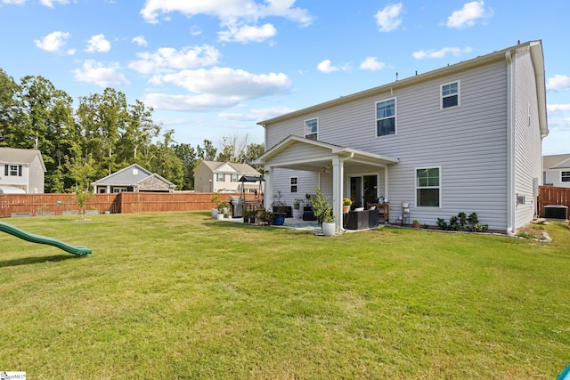 back of house featuring a playground, a patio, an outdoor living space, and a lawn