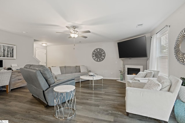 living room featuring ceiling fan and dark hardwood / wood-style flooring