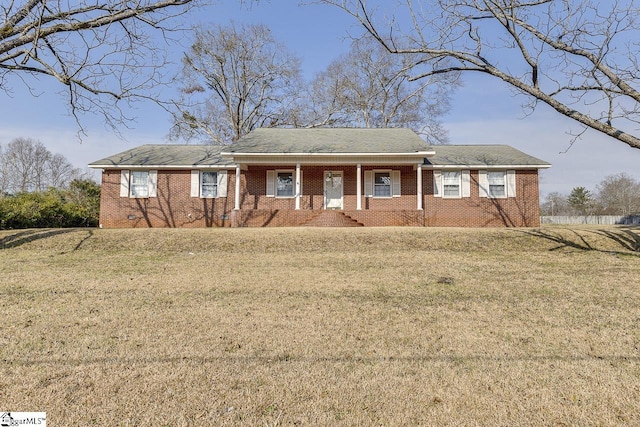 ranch-style home with covered porch and a front lawn