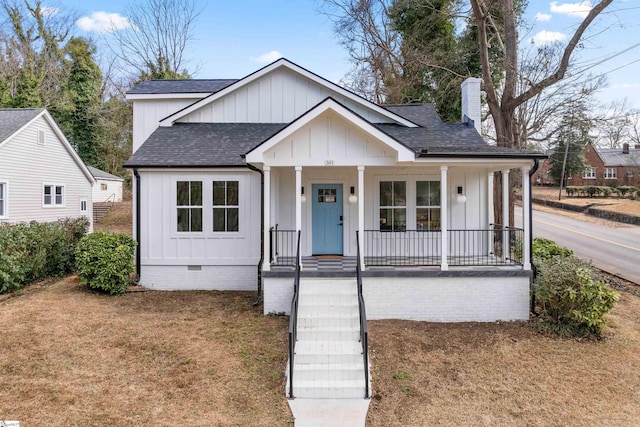 view of front of house with a front yard and covered porch