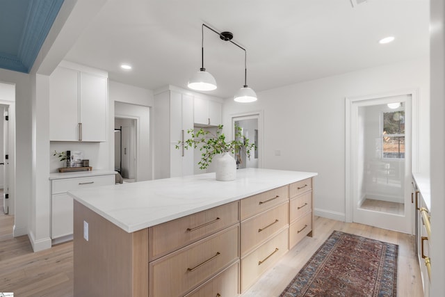 kitchen with white cabinetry, light hardwood / wood-style floors, a kitchen island, and light brown cabinets