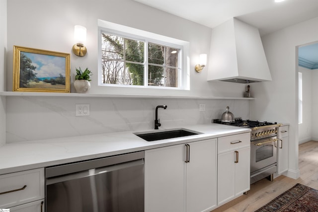 kitchen with sink, tasteful backsplash, appliances with stainless steel finishes, custom range hood, and white cabinets