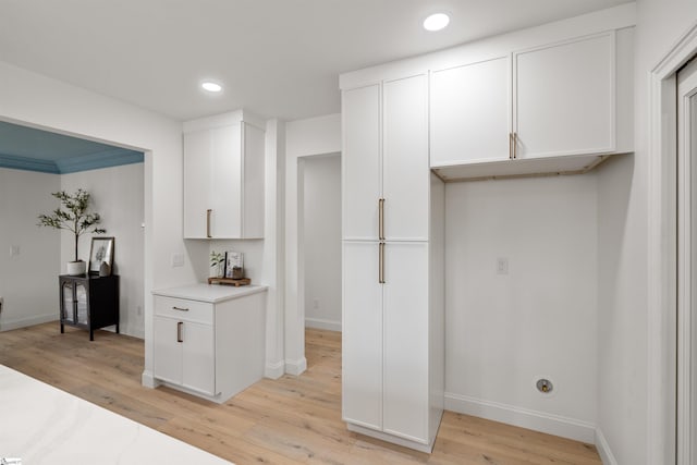 kitchen with light hardwood / wood-style flooring and white cabinets