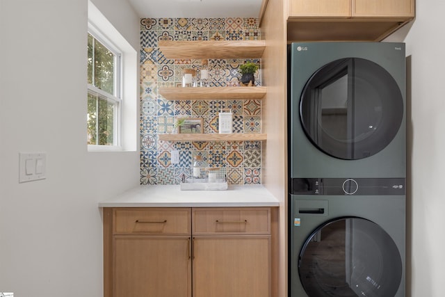 laundry room with cabinets and stacked washing maching and dryer