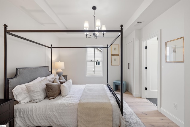 bedroom with a notable chandelier and light hardwood / wood-style flooring