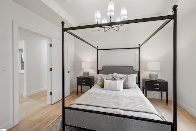 bedroom with an inviting chandelier and light wood-type flooring